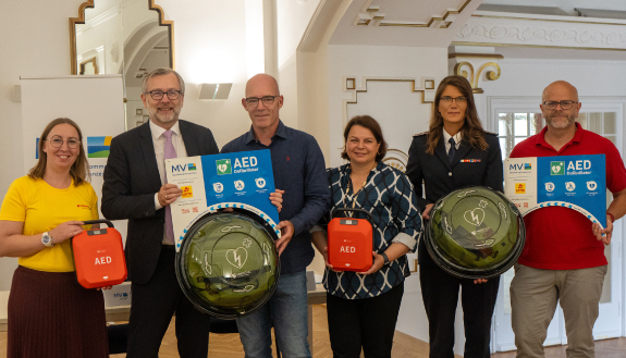 Defibrillatoren-Initiative: Drei Frauen und drei M&auml;nner mit Defibrillatoren stehen nebeneinander