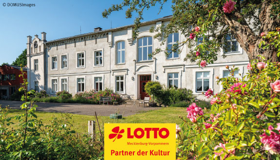 Das Denkmalgeschützte Herrenhaus Roggow in der Region Ostseegutsland mit Bäumen. Dazu das Logo von LOTTO MV - Partner der Kultur.