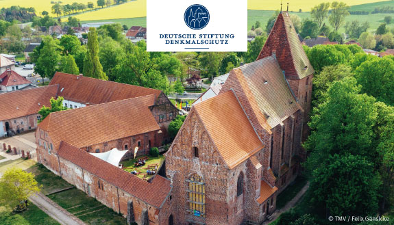 Klosteranlage Rehna - Backsteinbau umgeben von großen Bäumen