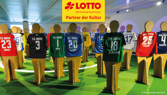 Verschiedene Fußballtrikots vom F.C. Hansa Rostock ausgestellt auf Pappaufstellern.