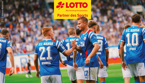 Logo LOTTO MV Partner des Sports und Hansaspieler in Vereinskleidung auf dem Spielfeld. Im Hintergrund Publikum.