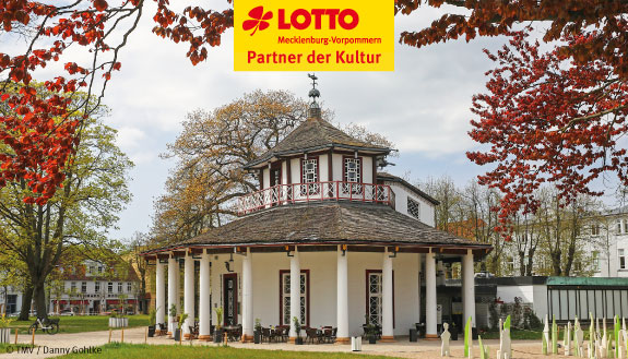 Der Weisse Pavillon in Bad Doberan umgeben von Laubbäumen im Herbst.