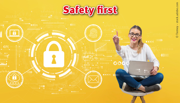 Lachende Frau mit Laptop sitzt auf Stuhl und zeigt auf kryptische Symbole