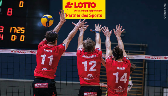 Drei Volleyballspieler springen am Netz.