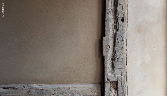 Holzbalken mit Gravur des Familiennamens Ollenborg