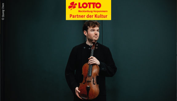 Schwarz gekleideter Mann h&auml;lt Geige vor seinem K&ouml;rper.