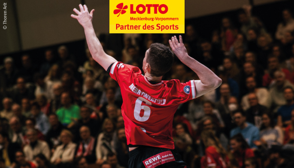 Volleyballspieler mit rotem Trikot springt hoch