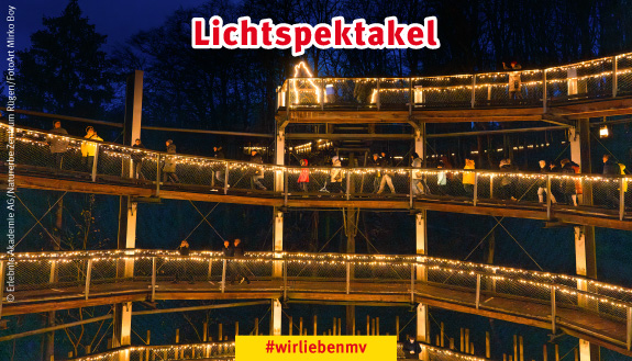 Beleuchteter Baumwipfelpfad mit vielen Menschen