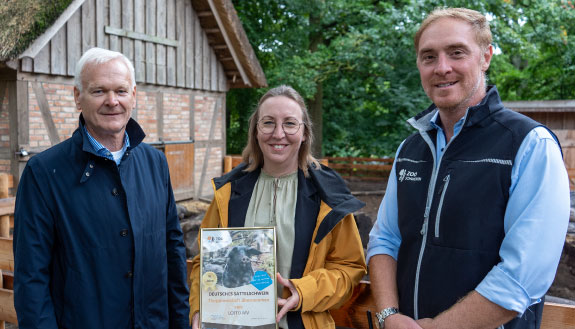 V.l.n.r.: Hubert Ludwig, Elisabeth Aßmann und Dr. Tim Schikora zeigen die Patenschaftsurkunde für das Deutsche Sattelschwein.