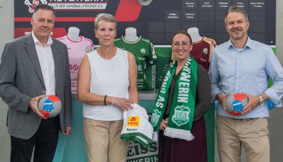 Vier Personen mit Handb&auml;llen, Trikots und Vereinsschal
